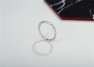 Draufsicht auf einen minimalistischen Silberperlenring auf Marmor und mattem Grund