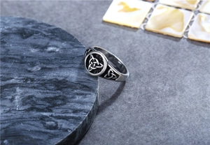 Close-up of vintage Viking steel ring featuring Celtic knot patterns on a stone surface