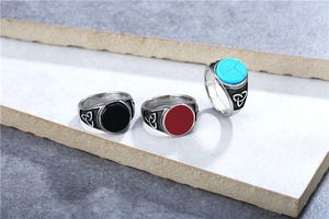 Macro shot of three vintage Viking rings with black, red, and turquoise stones