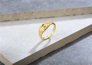 Vista de cerca del número 13 dorado con diseño calado en un anillo de acero inoxidable