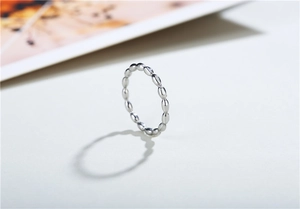 Makroaufnahme eines minimalistischen silbernen Perlenrings mit ovaler Textur