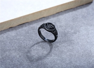 Close-up of vintage black stainless steel Viking ring with Celtic knot and cut-out patterns