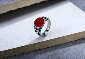 Detail of vintage Viking signet ring with red gem and Celtic knot engraving on silver band