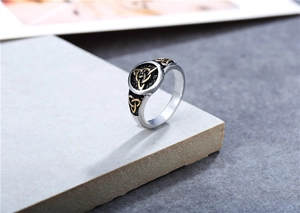 Close-up of vintage Viking steel ring featuring gold Celtic knot relief on silver metal