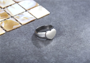 Detailed macro view of the silver heart-shaped stainless steel ring with polished mirror finish