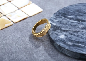 Makro-Detail der goldenen Federstruktur auf einem Vintage-Titanstahl-Ring für Damen