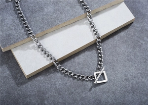 Détail d'un collier chaîne cubaine argentée avec fermoir à bascule carré industriel
