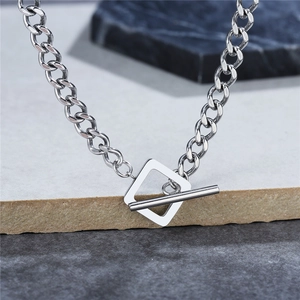 Collier à maillons cubains en acier inoxydable avec fermoir à bascule sur fond de pierre