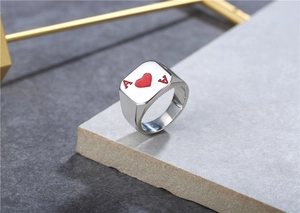Macro detail of silver Ace of Hearts poker ring with red enamel inlay on steel