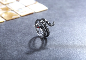 Vista macro di un anello a serpente retrò con scaglie nere e occhi di pietre rosse