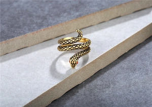 Dettaglio dell'anello a serpente retrò con finitura oro antico e occhi in pietra rossa