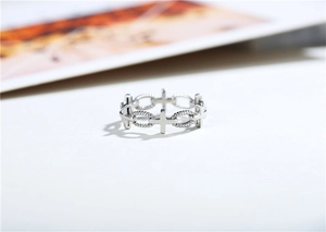 Close-up of gothic cross chain ring with polished surfaces and spiral textures
