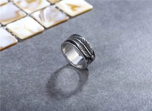 Macro shot of vintage titanium steel ring featuring detailed feather texture and polished finish