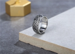 Detalle del grabado de nudo celta vikingo en un anillo de acero vintage para hombre
