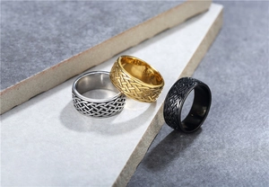 Primer plano de texturas de nudos celtas vikingos en anillos de acero plata, oro y negro