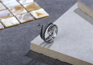 Dettaglio anello a serpente argento vintage con squame su sfondo di pietra