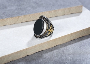 Detailed macro shot of vintage men's titanium steel ring with black stone and gold accents