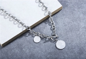 Detail of silver titanium steel necklace featuring Elizabeth II coin pendants and OT toggle clasp