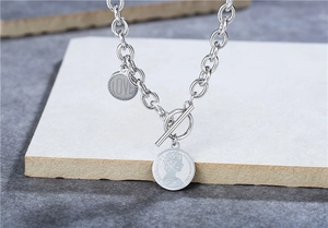 Detail of silver OT toggle chain necklace with engraved LOVE charm and coin pendant