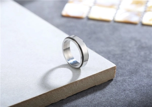 Macro shot of polished silver spinner ring with a minimalist center groove design