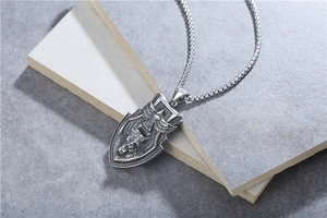 Detail of vintage eagle and wolf head relief on stainless steel shield pendant