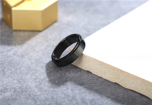 Detail of black spinning titanium steel ring with tiered edges on a stone display