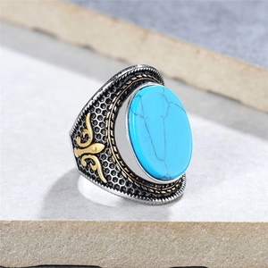 Vintage punk men's ring with oval blue stone and golden floral relief on silver band