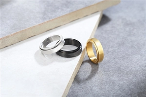 Three-color minimalist rotating stainless steel rings in silver, black, and gold tones