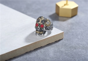 Macro détaillée d'une bague tête de mort vintage avec yeux rubis et détails en croix