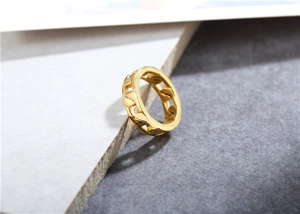 Macro detail of high-polished golden Cuban chain link ring on a grey surface