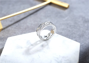Detailed view of silver Cuban chain ring on a white marble display stand with golden accents