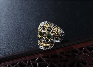 Bague crâne vintage avec croix dorée, yeux verts et détails en acier inoxydable poli
