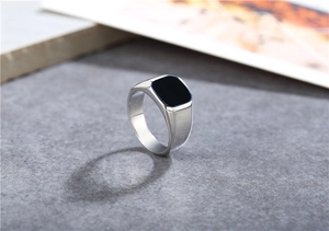 Detailed view of square black enamel inlay on polished stainless steel men's ring