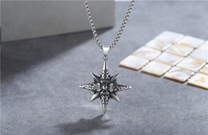 Macro shot of retro stainless steel compass star pendant with vintage relief texture