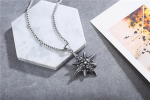 Vintage stainless steel compass star pendant on a square pearl chain over white stone