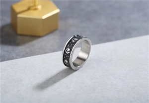 Detailed relief of sun moon and star patterns on a vintage steel ring with antique finish