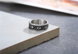 Macro detail of retro sun moon and star relief patterns on vintage titanium steel ring