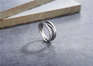 Close-up of retro silver multilayer intertwined titanium steel ring on stone surface