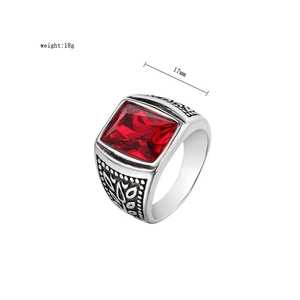 Macro detail of men's vintage signet ring with red gem and detailed relief engravings