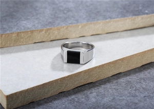 Macro shot of polished titanium steel ring with a rectangular black agate inlay