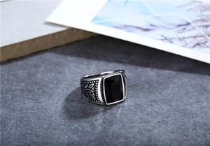 Macro detail of retro men's steel ring with rectangular black gemstone and leaf carvings