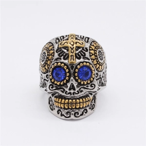 Bague tête de mort gothique en acier argent et or avec yeux en strass bleus sur blanc