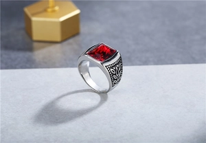 Detailed close-up of retro titanium steel ring featuring a square red gemstone and engraving