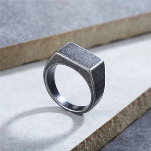 Vintage matte titanium steel signet ring with rectangle face on textured stone