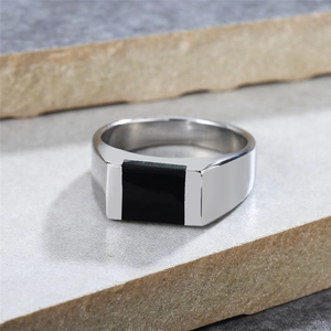 Minimalist silver titanium steel ring with black rectangular inlay on a textured stone base