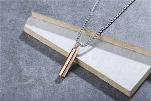 Detailed macro view of a rose gold perfume bottle pendant on a silver box fox chain