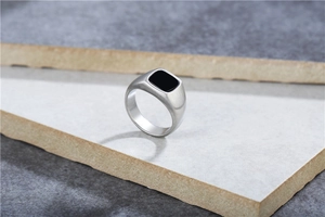 Detalle de anillo de acero de titanio cepillado con incrustación de piedra negra mate