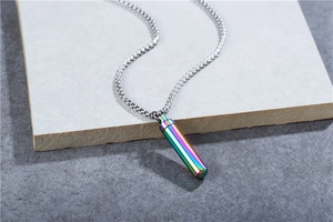 Detailed macro of a cylindrical rainbow-colored urn pendant on a steel pearl chain