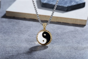 Macro detail of Yin Yang pendant with black white enamel and golden engraved vintage frame