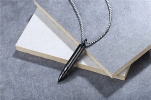 Détail du collier pendentif balle noire avec strass sur carreaux de pierre grise